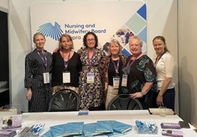 6 women standing together behind a booth